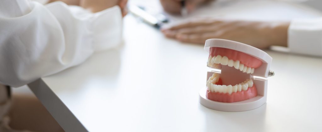 Patient with a toothache sees a dentist in a dental clinic at a hospital examination room. The doctor gives advice on maintaining oral health.